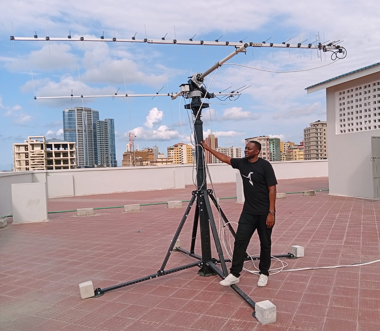 Rooftop tracking antenna installation at DIT, Dar es Salaam skyline in the background