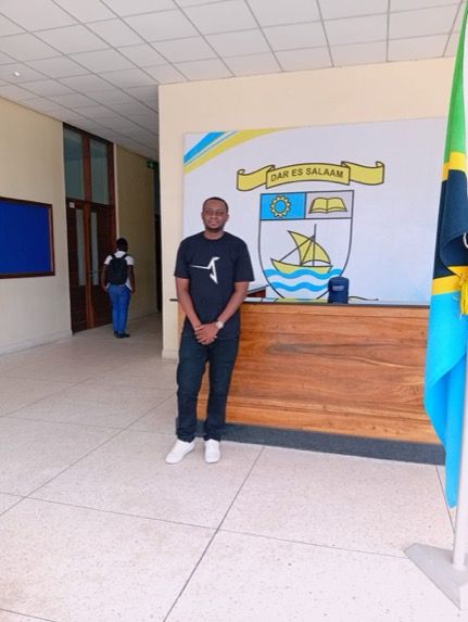 Leonard Shayo in front of DIT building signage