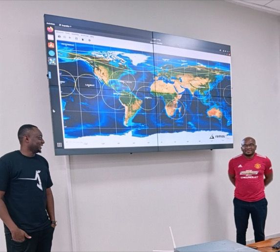 Leonard Shayo and Dr. Moses in front of the video wall
